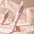 Pink automatic hair curler with open 32mm rotating chamber on a marble stand