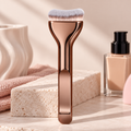 Curved foundation brush with rose gold handle next to a foundation bottle