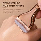 Curved brush blending foundation on the back of a hand with no brush marks